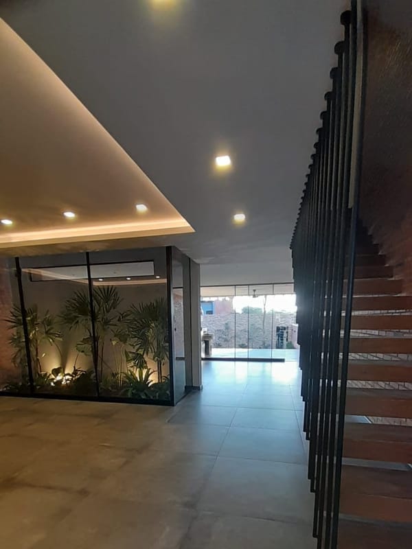 Hall de una casa con iluminación LED perimetral y luces empotradas