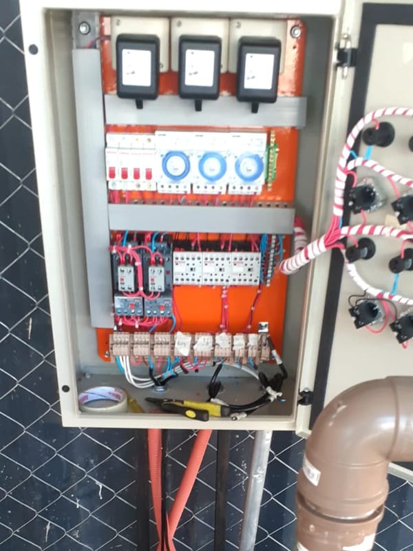 Tablero de comando con temporizadores y contactores, junto a una instalación de cañerías
